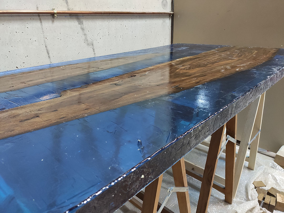 Tabla de nogal con resina epoxi azul detalle