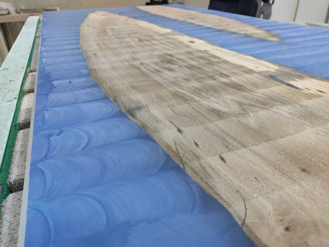 Tabla de madera de nogal y resina epoxi azul en lijado